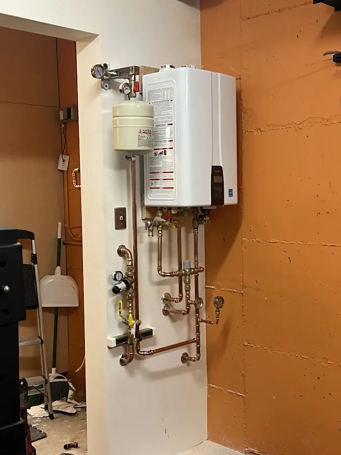 Plumbing technician inspecting water heater connections in Bernards